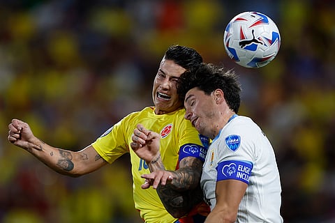 James Rodriguez and Jose Gimenez jump for a header